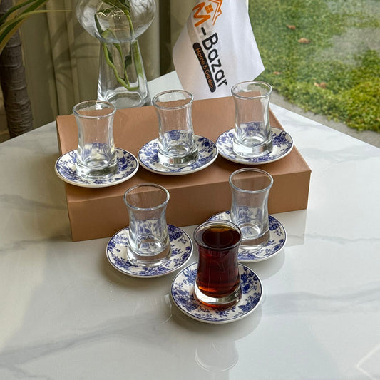 أكواب شاي زجاجية مع صحون مزخرفة بنقوش زهور زرقاء